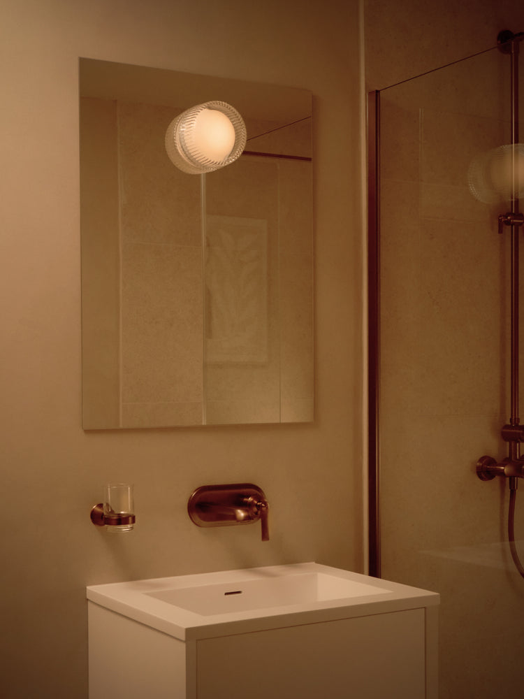 Firth Wall Light by Tala: an IP65-rated puck light mountable on a wall or mirror. Fit with Dim-to-Warm technology, Firth provides a perfect glow indoors or outdoors.