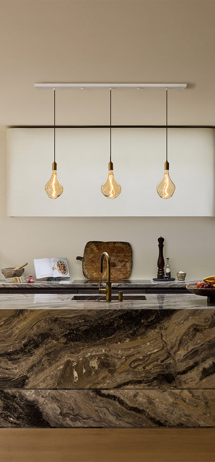 Linear Triple Pendant + Voronoi II lighting up a kitchen island setting. Tala's linear pendants are perfect for elongated kitchen spaces, elevating the space beautifully.