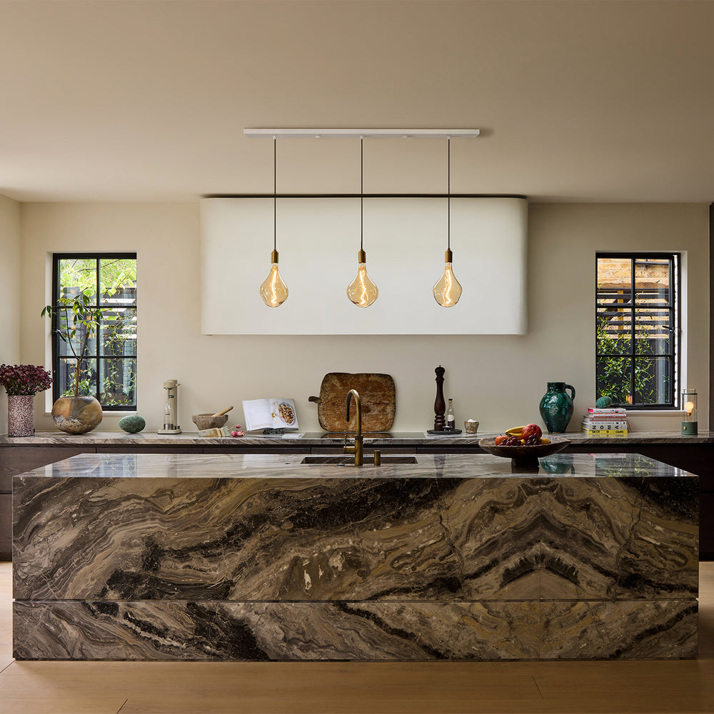 Linear Triple Pendant + Voronoi II lighting up a kitchen island setting. Tala's linear pendants are perfect for elongated kitchen spaces, elevating the space beautifully.