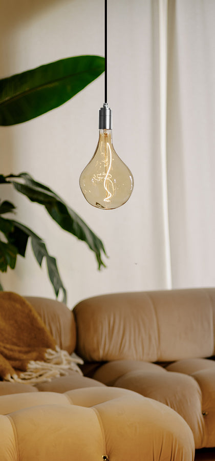 Our new Silver Pendant light paired with a Voronoi II bulb in a living room setting, bringing cozy warmth to the environment.
