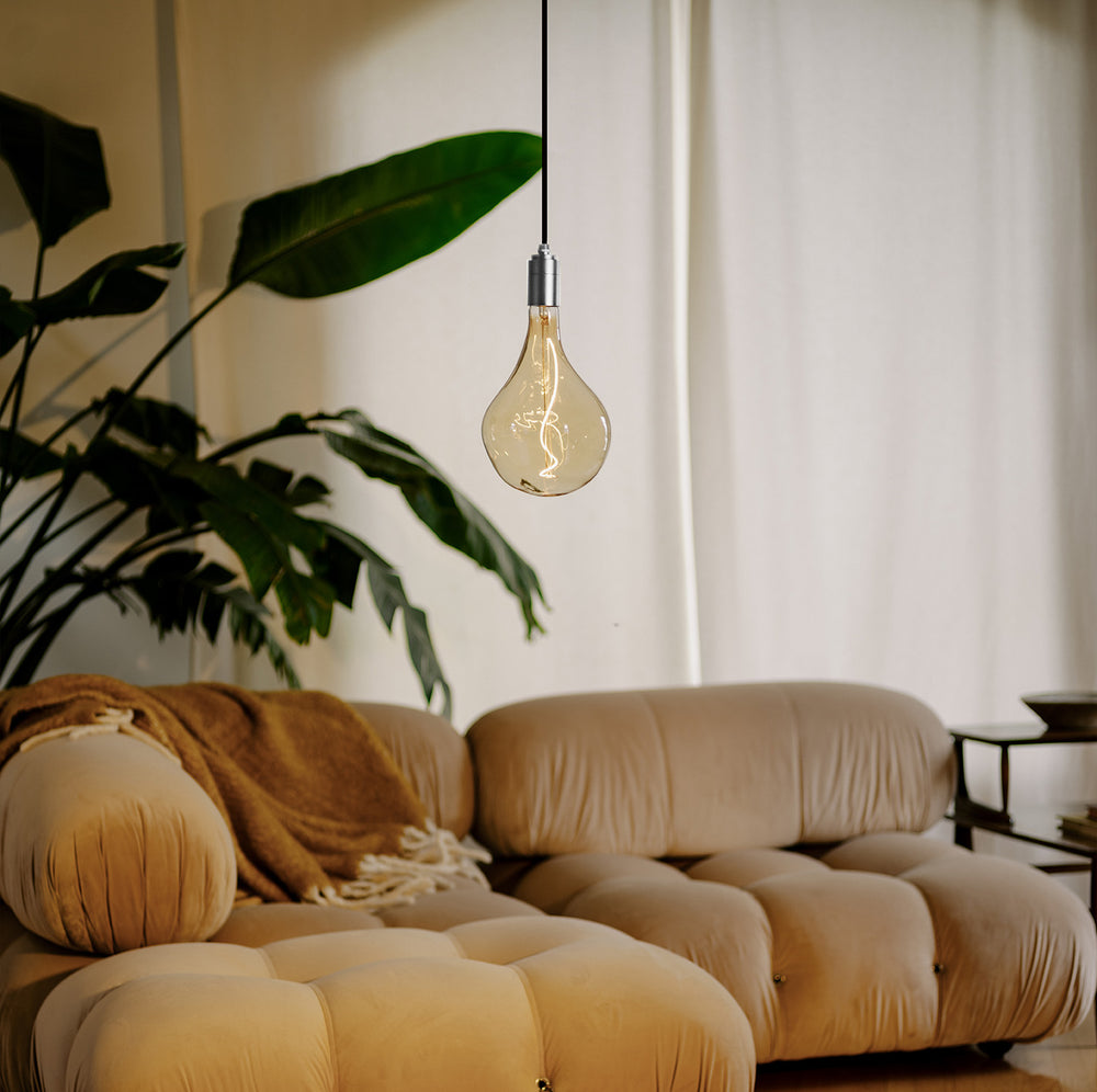 Our new Silver Pendant light paired with a Voronoi II bulb in a living room setting, bringing cozy warmth to the environment.