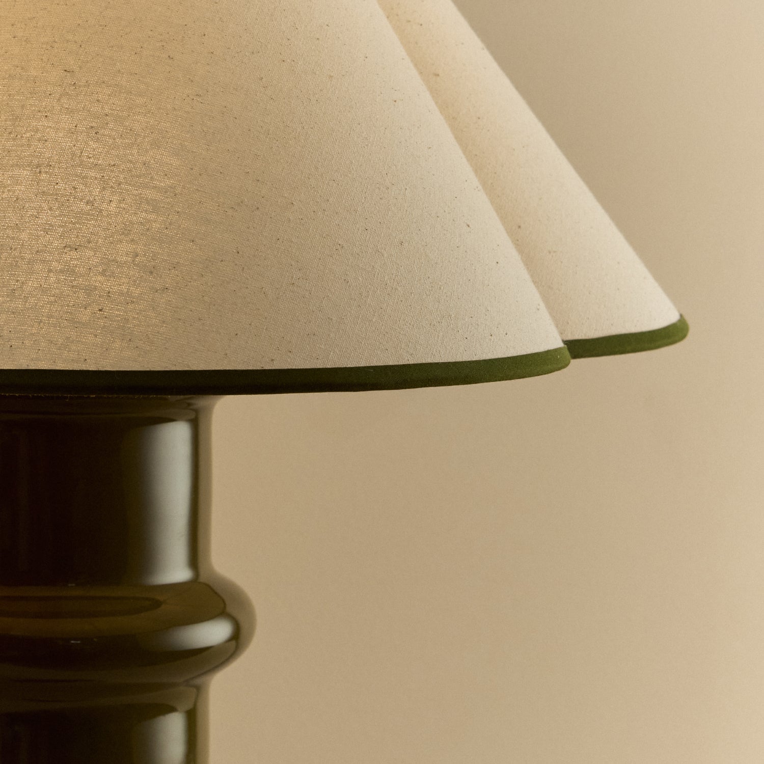 Close-up of the Heath Table Lamp's natural cotton shade with its scalloped edge and olive green trim